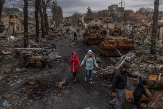 Bucha residents walk past destroyed Russian military vehicles after Ukrainian forces liberated the town. April 6, 2022.