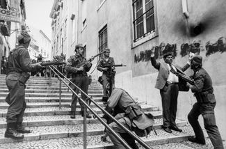 Солдаты арестовывают сотрудника тайной полиции после «революции гвоздик» в Лиссабоне. Апрель 1974 года